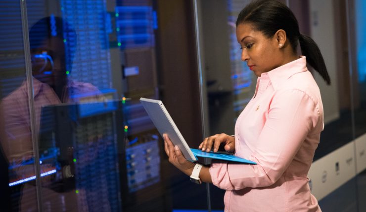 woman looking at data & using laptop