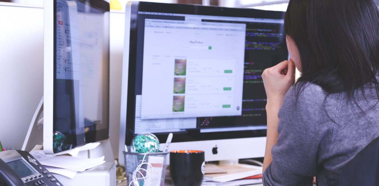 woman working on double screen computer