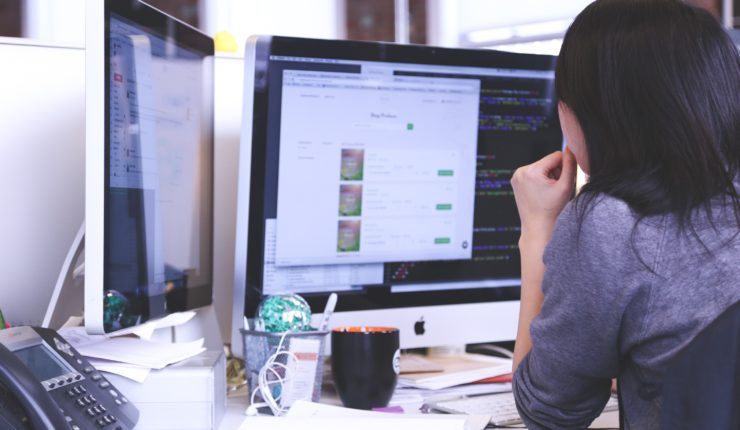 woman working on double screen computer