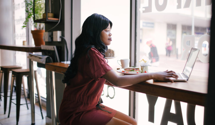 Woman working on laptop in a cafe
