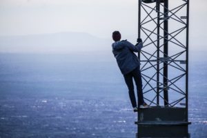 a man climbing a phone mast