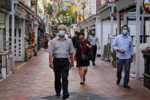 people walking down a street with masks on