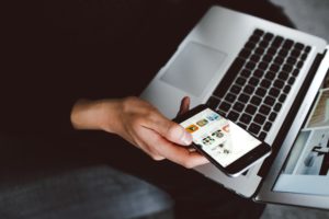man using phone and laptop