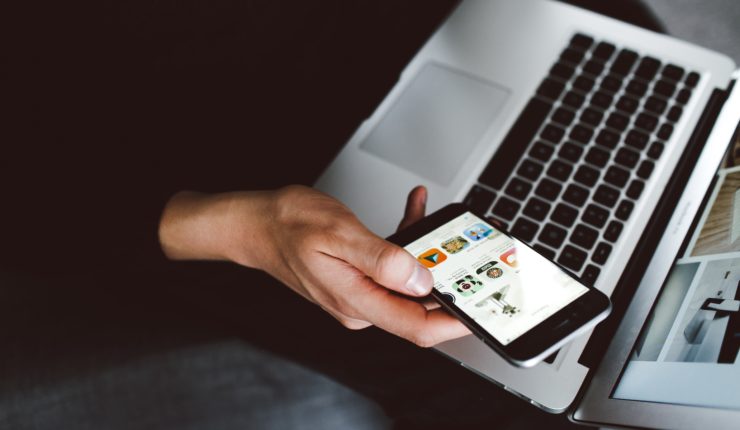man using phone and laptop