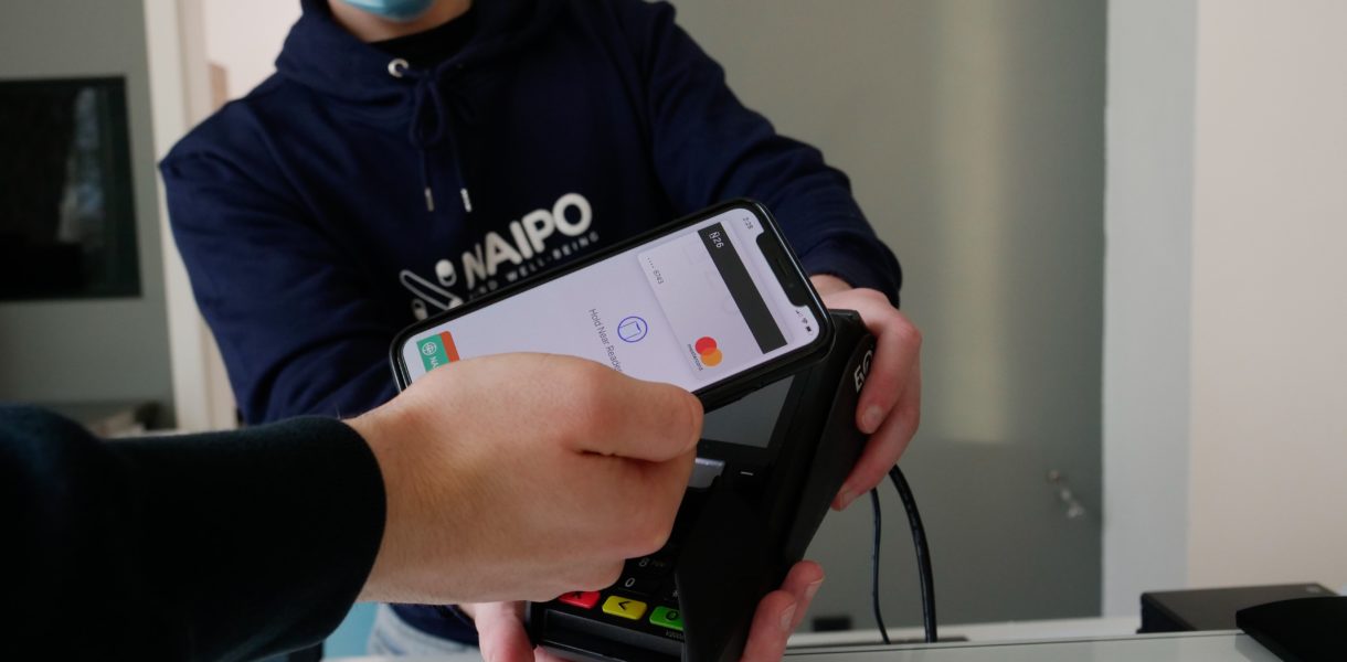 someone paying contactless with facemask