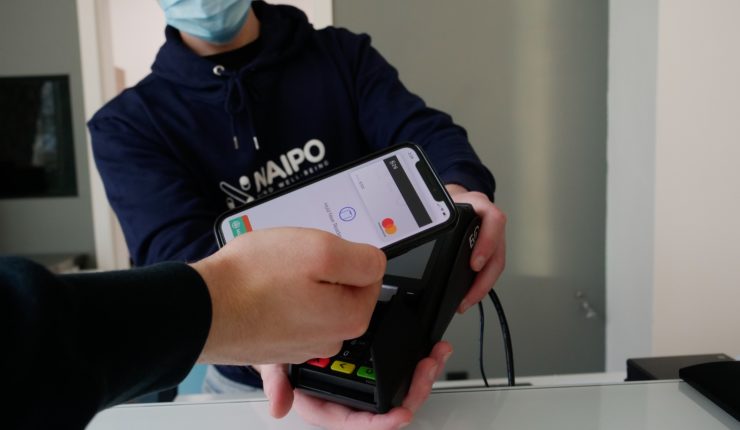 someone paying contactless with facemask