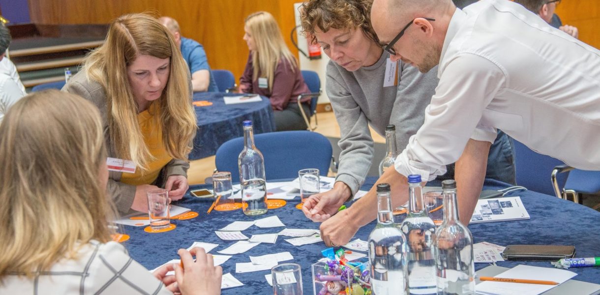 4 people round table looking at lables