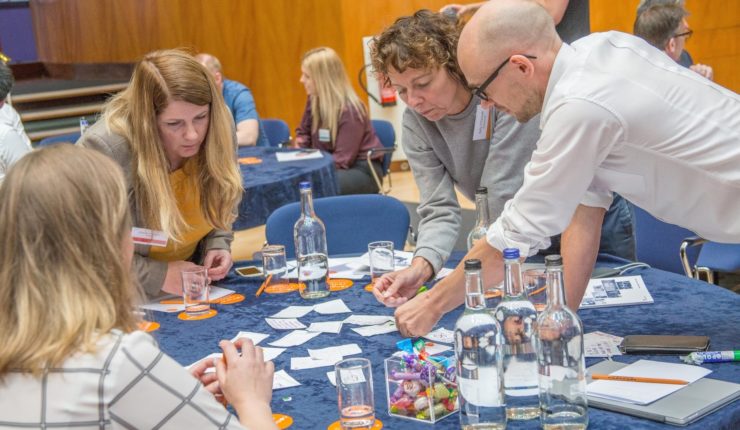 4 people round table looking at lables