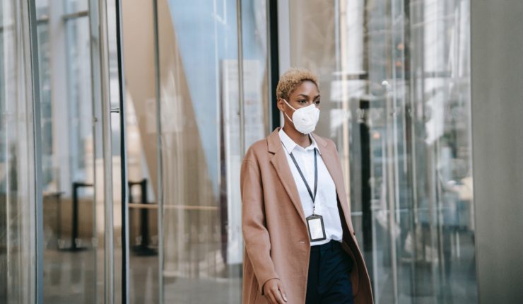Woman wearing a mask outside office block
