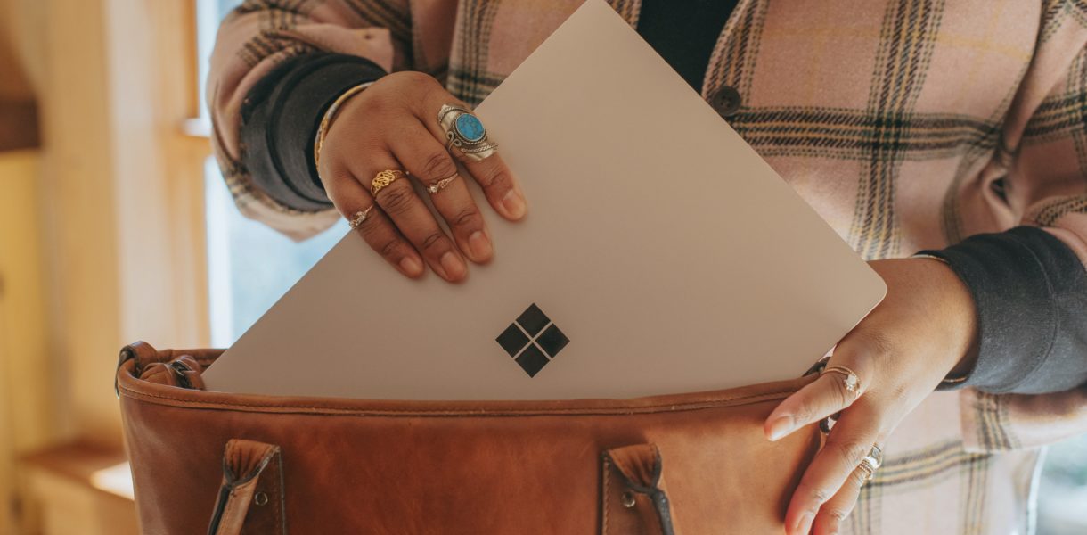 a woman putting microsoft laptop in a bag