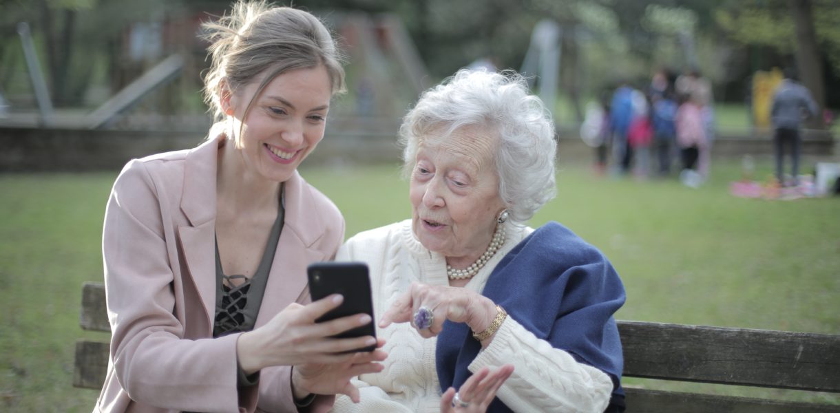 young lady and elderly using a mobile phone