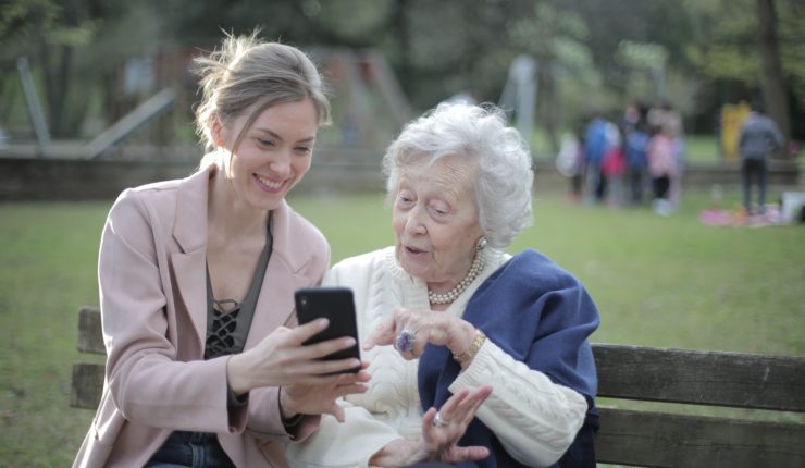 young lady and elderly using a mobile phone