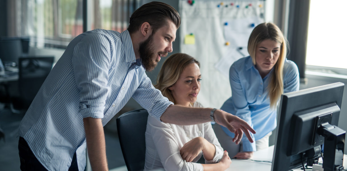 Coworkers,Looking,At,A,Computer,And,Talking,About,Work.