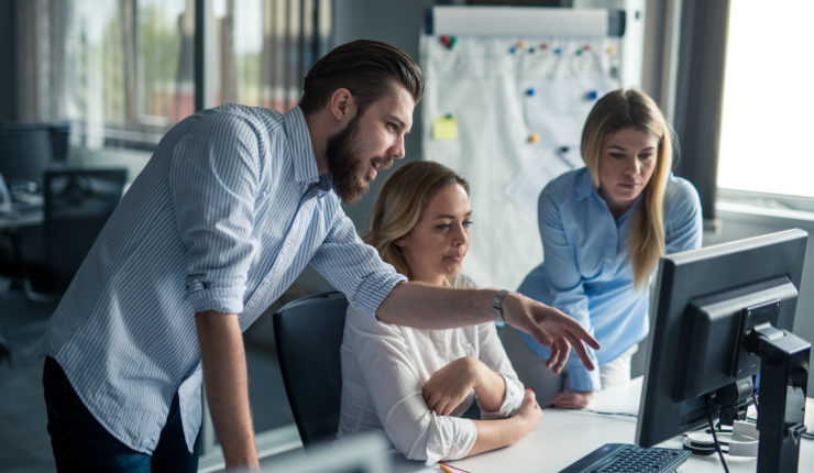 Coworkers,Looking,At,A,Computer,And,Talking,About,Work.