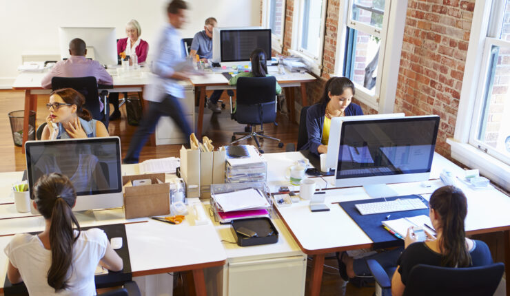 Wide,Angle,View,Of,Busy,Design,Office,With,Workers,At