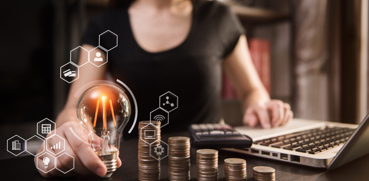 Accountant,Hand,Holding,Lightbulb,With,Using,Laptop,Computer,And,Money
